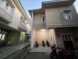 two motorcycles parked in front of a building at Hotel O Anugrah Homestay Syariah in Makassar