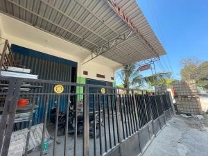 a gate in front of a building with a motorcycle at SPOT ON 93037 Nova Jaya Homestay Syariah in Lamongan