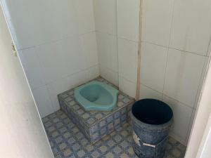 een kleine badkamer met een blauw toilet en een emmer bij SPOT ON 93037 Nova Jaya Homestay Syariah in Lamongan