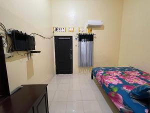 a room with a bedroom with a bed and a door at OYO Life 93032 Maju Mapan Homestay Syariah in Lamongan