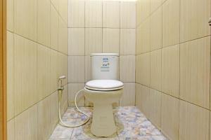 ein Bad mit einem WC in einer gefliesten Wand in der Unterkunft OYO 92998 Wiludjeng Guesthouse in Sragen