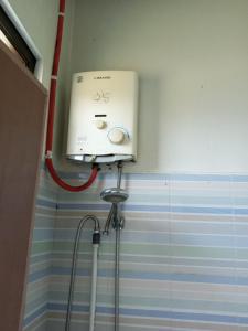 eine Dusche im Bad mit einem Wassertank in der Unterkunft OYO 93012 Griya Kencana Asri Syariah in Lawean