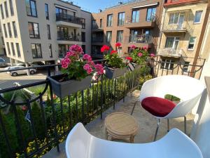 a balcony with some flowers on a fence at Spacious Old Town Apartment, 3 Rooms, Free Parking, Sleeps up to 7 in Kaunas
