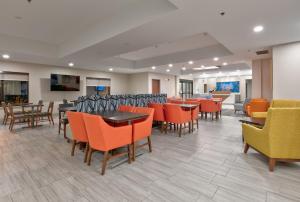 a waiting room with tables and chairs in a hospital at Holiday Inn Express Hotel & Suites Shakopee, an IHG Hotel in Shakopee