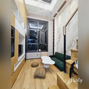 a living room with a green couch and a window at Luxury Apartment near Lotte World in Seoul