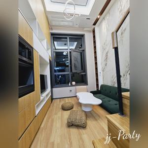 ソウルにあるLuxury Apartment near Lotte Worldのリビングルーム(緑のソファ、テレビ付)