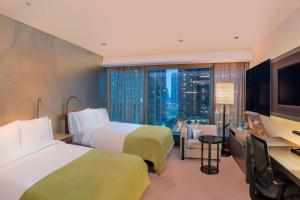 a hotel room with two beds and a television at W Hong Kong in Hong Kong