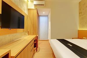 a bedroom with a bed and a flat screen tv at Capital O 92987 Keenan Living Perumnas in Yogyakarta