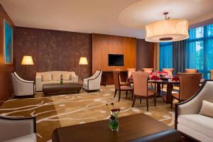 a living room with a dining area and a living room with a couch at Sheraton Bailuhu Resort, Huizhou in Huizhou