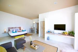 a living room with a couch and a tv at Lime N Soda Beachfront Resort in Thong Sala