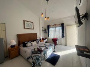 1 dormitorio con 1 cama y TV en Caribbean Queen, en Cancún