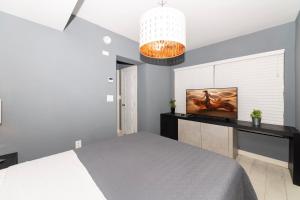 a bedroom with a bed and a tv on a wall at Sunny Days Apartments in Miami Beach