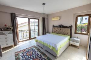 Un dormitorio con una cama y una ventana grande. en Havuzu, plajı, bahçesi ve olağanüstü manzarasıyla…, en Kas