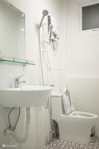 a white bathroom with a sink and a toilet at Nhà của Sóc in Da Lat