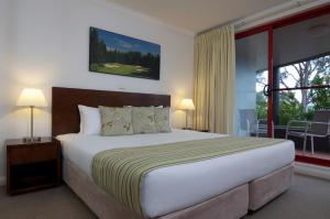 a bedroom with a large bed and a large window at Club Wyndham Port Stephens in Salamander Bay