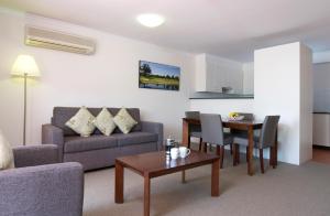 ein Wohnzimmer mit einem Sofa und einem Tisch in der Unterkunft Club Wyndham Port Stephens in Salamander Bay