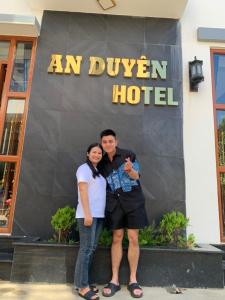 un hombre y una mujer parados frente a un hotel en Khách sạn ĐẢO LÝ SƠN- AN DUYÊN, en Quảng Ngãi