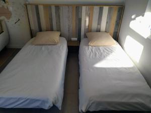 dos camas sentadas una al lado de la otra en una habitación en Studio 26, en Vic-le-Comte
