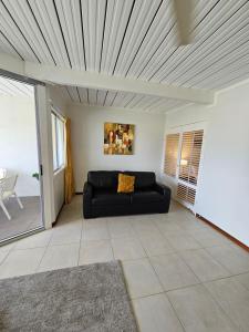 Airlie Seaview Apartments في شاطئ إيرلي: غرفة معيشة مع أريكة سوداء في غرفة