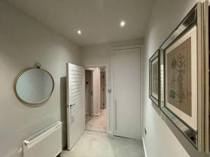 a hallway with a mirror on the wall and a hallway with a mirror at Quintessential Town House Close to Central London in London