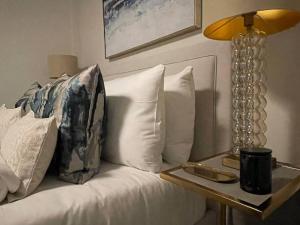 a white couch with a lamp and a tray on it at Quintessential Town House Close to Central London in London