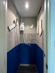 uma casa de banho com um chuveiro e uma parede azul em Comfy Crib Hostel em Bangkok