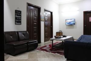 a waiting room with a leather chair and a table at Sapphire Heights Margalla Road Islamabad in Islamabad