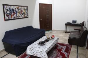 - un salon avec un lit, une table et une chaise dans l'établissement Islamabad Holiday Appartments One & Two Bed A Perfect Winter Escape to Murree, Northern Areas & Beyond, à Islamabad