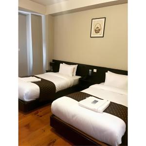 pokój hotelowy z 2 łóżkami z białą pościelą w obiekcie Hotel Dorjiling w mieście Paro