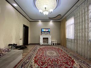 uma sala de estar com lareira e televisão em My Hovli em Tashkent