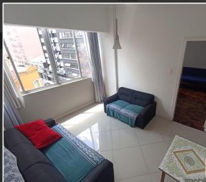 sala de estar con sofá y silla en 123m Apartamento Centro de Curitiba, en Curitiba