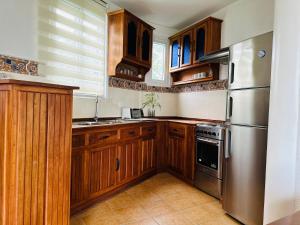 La cuisine est équipée d'armoires en bois et d'un réfrigérateur en acier inoxydable. dans l'établissement Aissatou Beach Resort, à Boracay