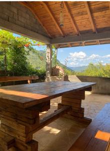- une grande table en bois sur une terrasse avec vue dans l'établissement Apartman LENNA, à Trebinje