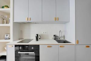 a white kitchen with white cabinets and a sink at Saint-Honoré Beautiful apartment 4 people in Paris