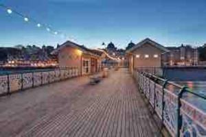 a boardwalk with buildings on it next to the water at The Little Lodge - seaside town of Penarth nr Cardiff in Penarth