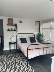 a bedroom with a bed and a lamp on a rug at The Little Lodge - seaside town of Penarth nr Cardiff in Penarth