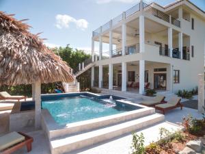 a villa with a swimming pool and a house at Laguna Gecko Villa in Placencia Village