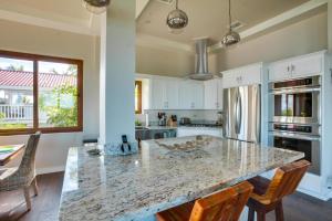 a kitchen with a marble counter top and a island at Laguna Gecko Villa in Placencia