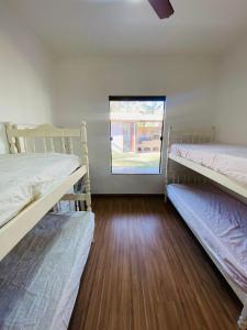 two bunk beds in a room with a window at Casa com piscina e jacuzzi in Cabo Frio +38 photos