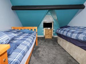 2 camas en una habitación con una pared azul en Glanffrwd - Nefyn en Pwllheli