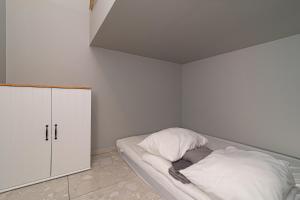 a small bedroom with a bed and a cabinet at Secret SPA in Vilnius