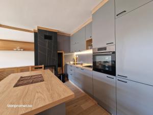 a kitchen with white cabinets and a wooden table at Sun&Snow Jahorina in Jahorina