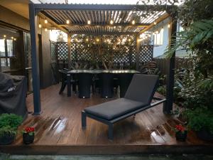 a patio with a table and a chair on a deck at Vicroad The Mount in Mount Maunganui