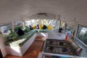 - Sala de estar en una cabaña con almohadas y fogones en CasaBus beautiful bus dept. 50m from beach, en Santa Cruz