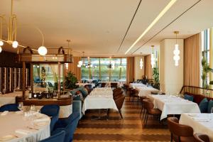 a dining room with white tables and chairs at Crowne Plaza Belgrade by IHG in Belgrade