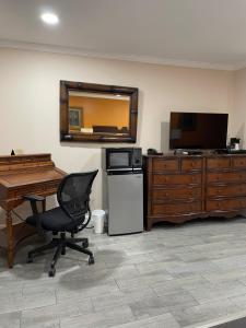 an office with a desk and a chair and a television at Howard Johnson by Wyndham Ridgecrest, CA in Ridgecrest