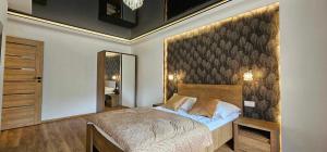 a bedroom with a large bed and a large mirror at Apartament S24 in Przemyśl