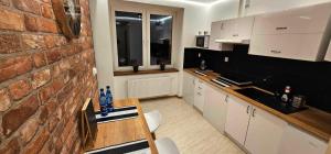 a kitchen with a table and a brick wall at Apartament S24 in Przemyśl +7 photos