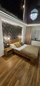 a bedroom with a large bed and a wooden floor at Apartament S24 in Przemyśl