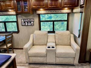 a living room with a couch in a train car at Happy Hedgehog River Views Hot Tub Private in Ahwahnee +18 photos